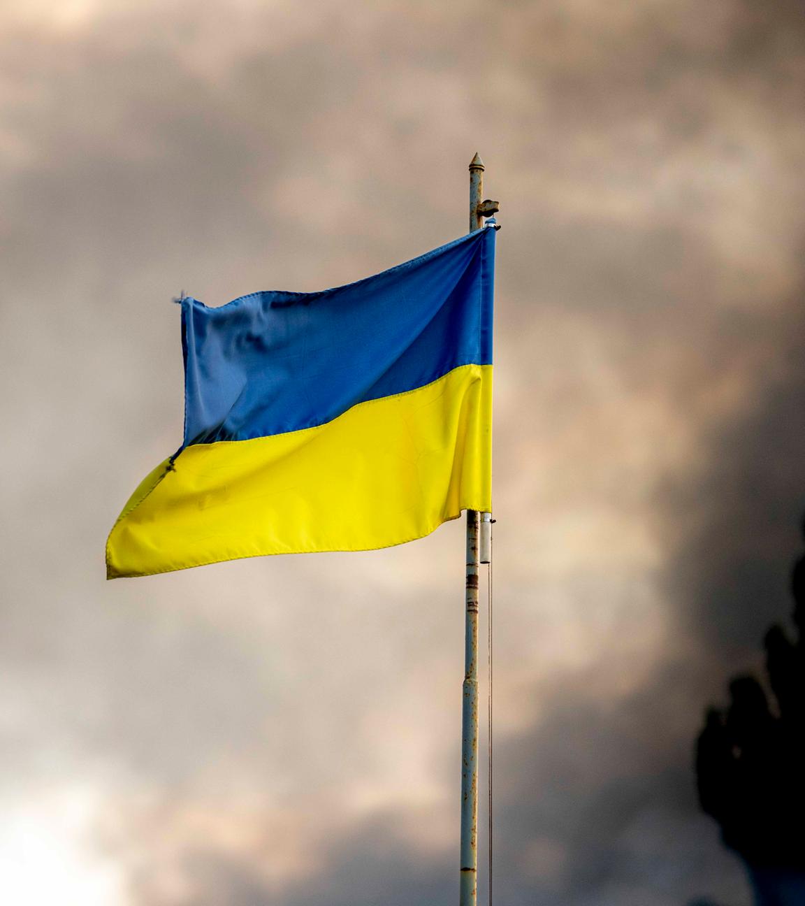 Ukrainische Flagge vor Rauch eines Feuers