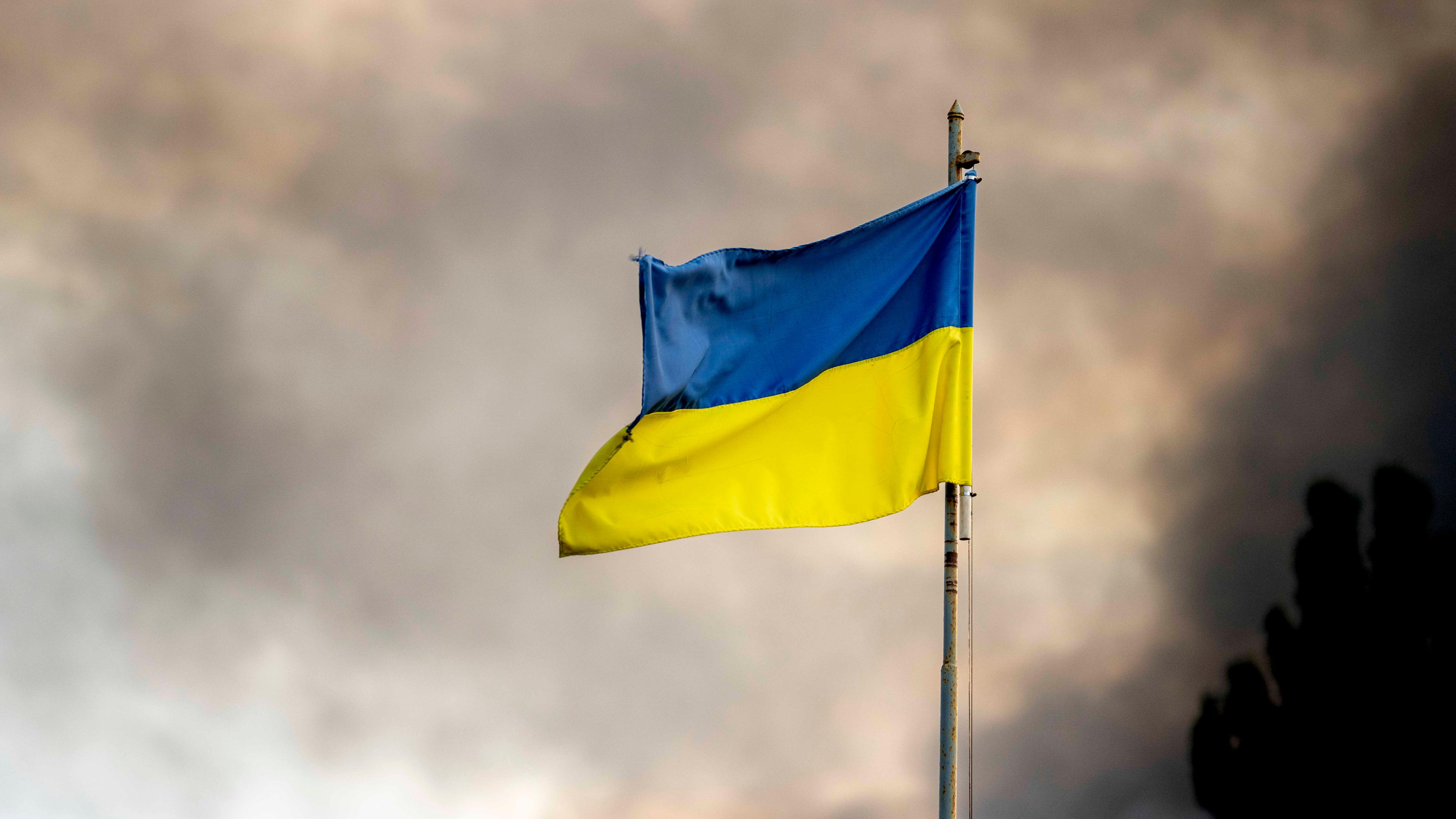 Ukrainische Flagge vor Rauch eines Feuers