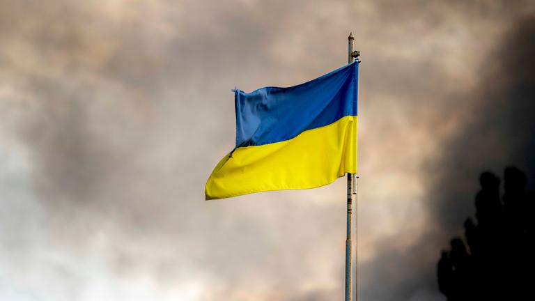 Ukrainische Flagge vor Rauch eines Feuers