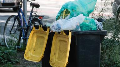 Überfüllte Mülltonnen für Plastikmüll