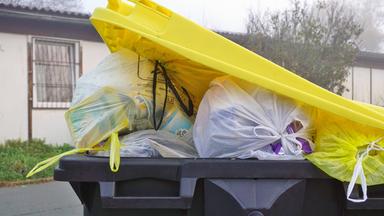 Überfüllte Mülltonne für Plastikmüll
