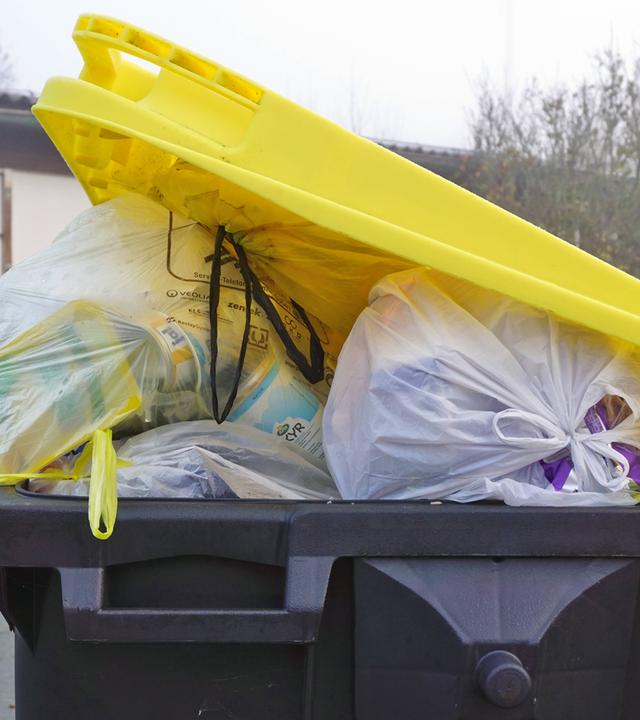 Überfüllte Mülltonne für Plastikmüll