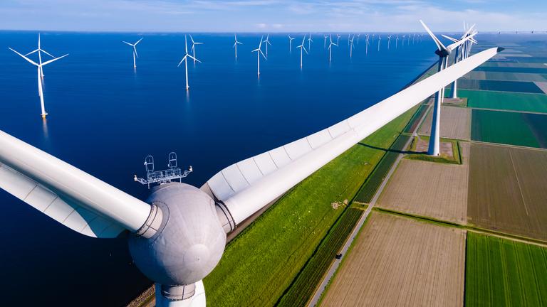 Offshore-Windmühlenpark mit Wolken und blauem Himmel, Windmühlenpark im Meer Drohnen-Luftaufnahme mit Windkraftanlage Flevoland