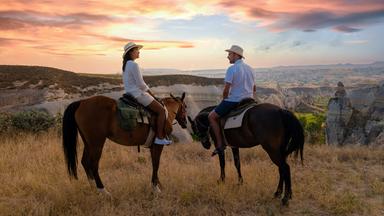 glückliches junges Paar im Urlaub Türkei Kapadokya Reiten in den Bergen von Kappadokien Goreme