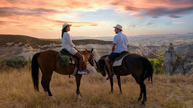 glückliches junges Paar im Urlaub Türkei Kapadokya Reiten in den Bergen von Kappadokien Goreme