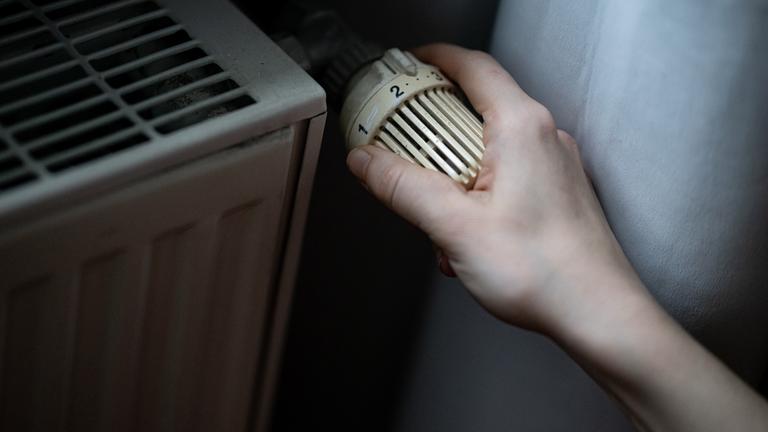 Thermostat wird an Heizung gedreht - Inflation