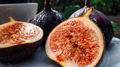 Delicate Fresh Ripe Figs With Leaves On White Plate, Rustic Wooden Table. Ficus