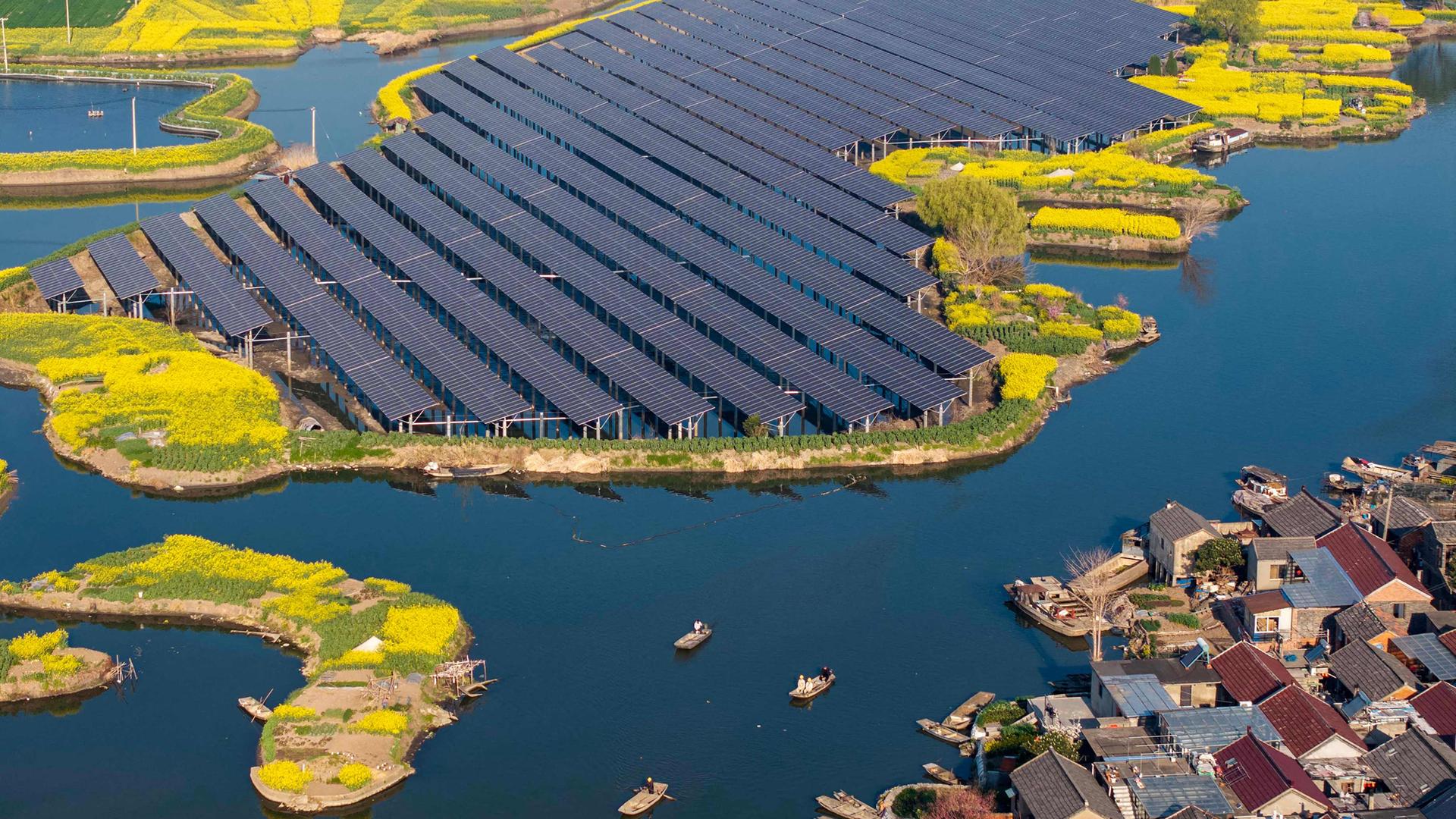 Eine Luftaufnahme zeigt Solarmodule neben Rapsfeldern in einem Dorf in Taizhou in der ostchinesischen Provinz Jiangsu.