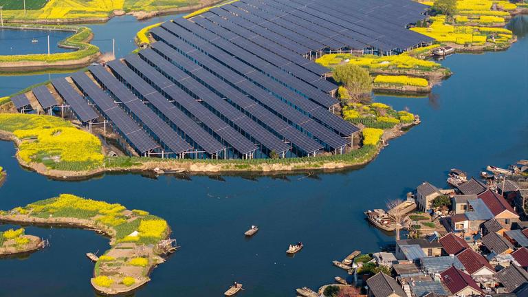 Eine Luftaufnahme zeigt Solarmodule neben Rapsfeldern in einem Dorf in Taizhou in der ostchinesischen Provinz Jiangsu.