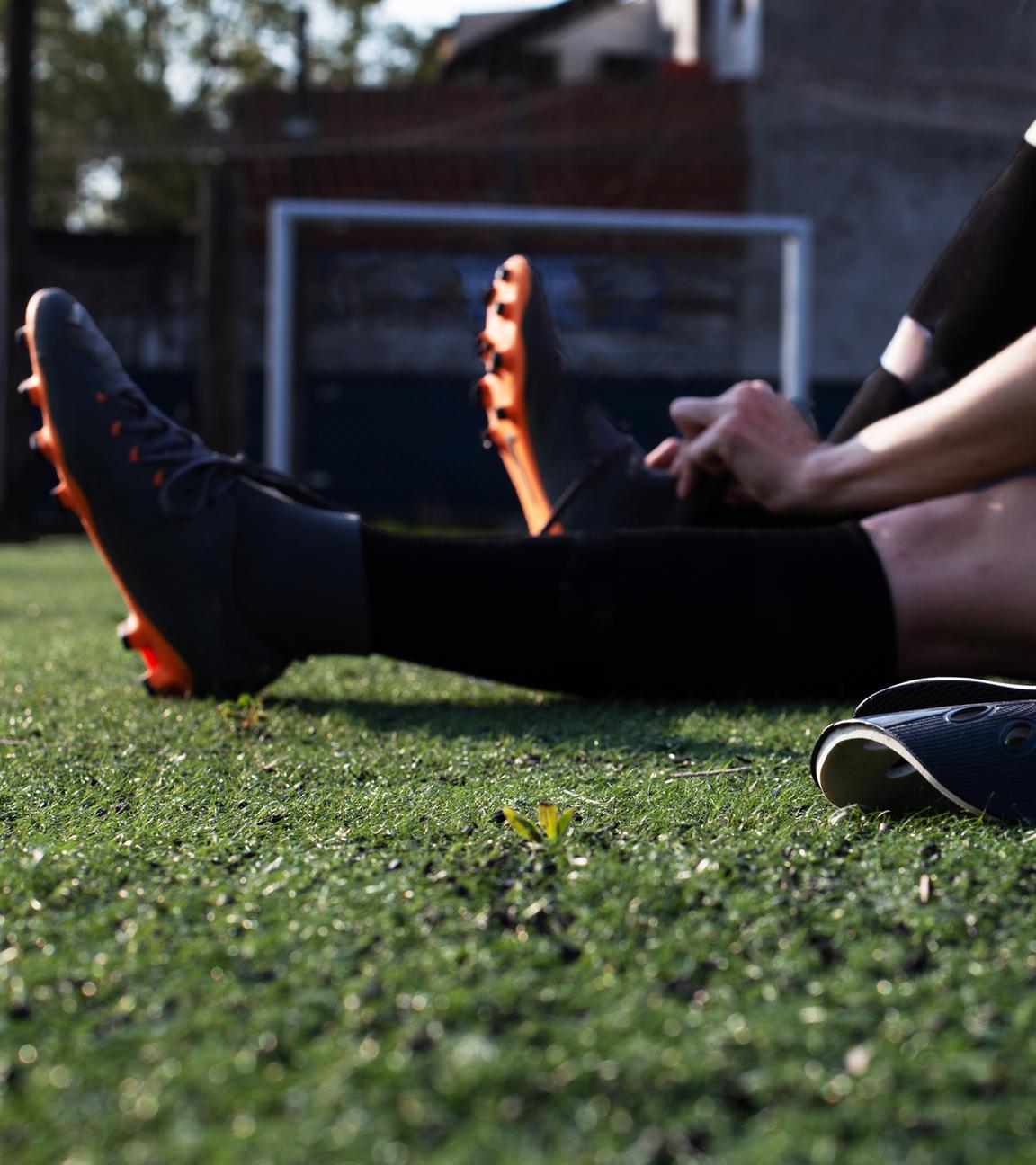 Frau bindet ihre Fußballschuhe