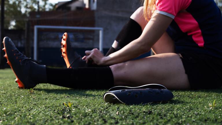Frau bindet ihre Fußballschuhe