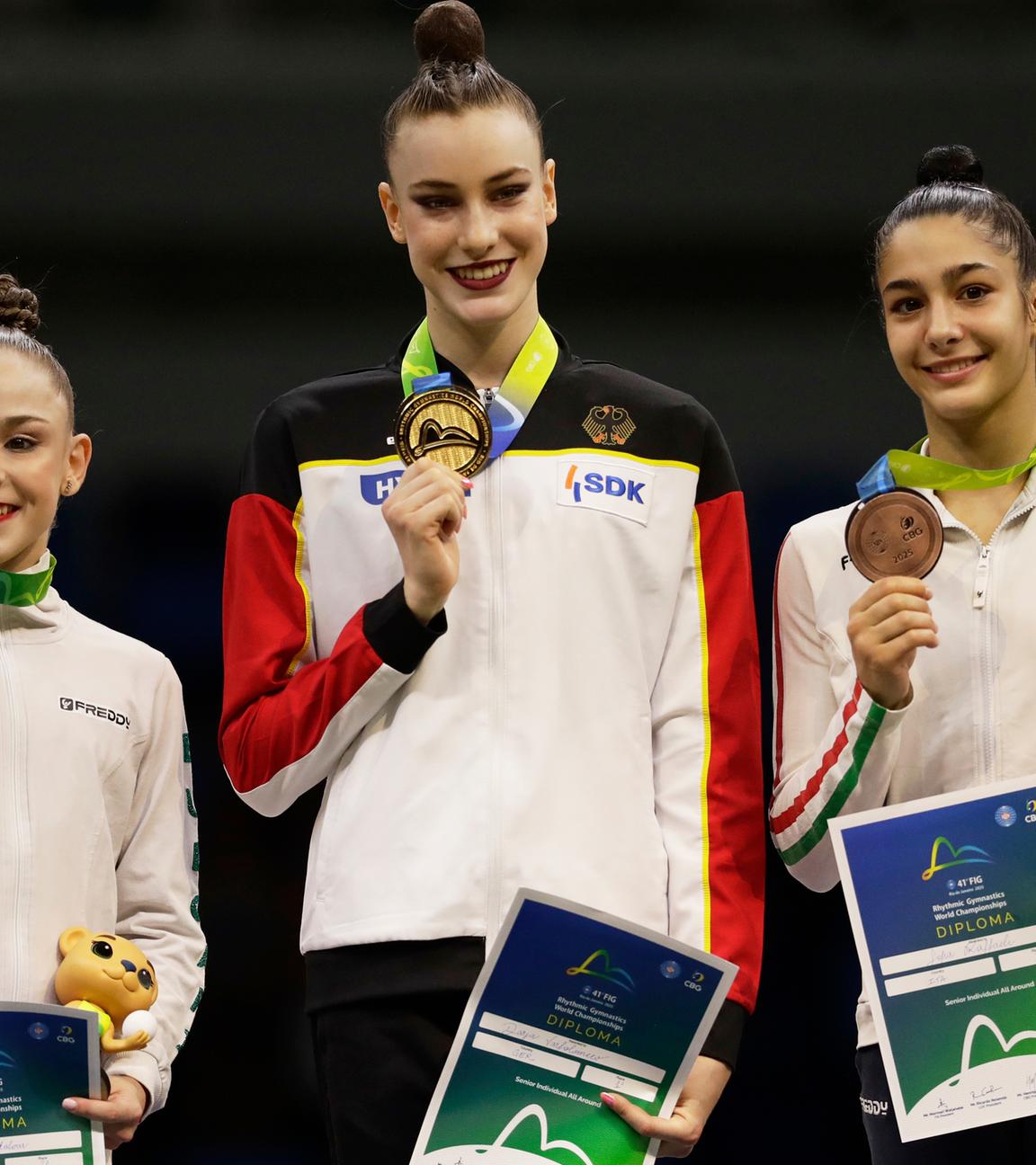 Die Goldmedaillengewinnerin Darja Varfolomeev aus Deutschland (Mitte), die Silbermedaillengewinnerin Stiliana Nikolova aus Bulgarien (links) und die Bronzemedaillengewinnerin Sofia Raffaeli aus Italien posieren auf dem Podium für die Siegerinnen des Einzelmehrkampfs bei den 41. FIG-Weltmeisterschaften im rhythmischen Turnen in der Carioca Arena in Rio de Janeiro am Freitag, 22. August 2025. 