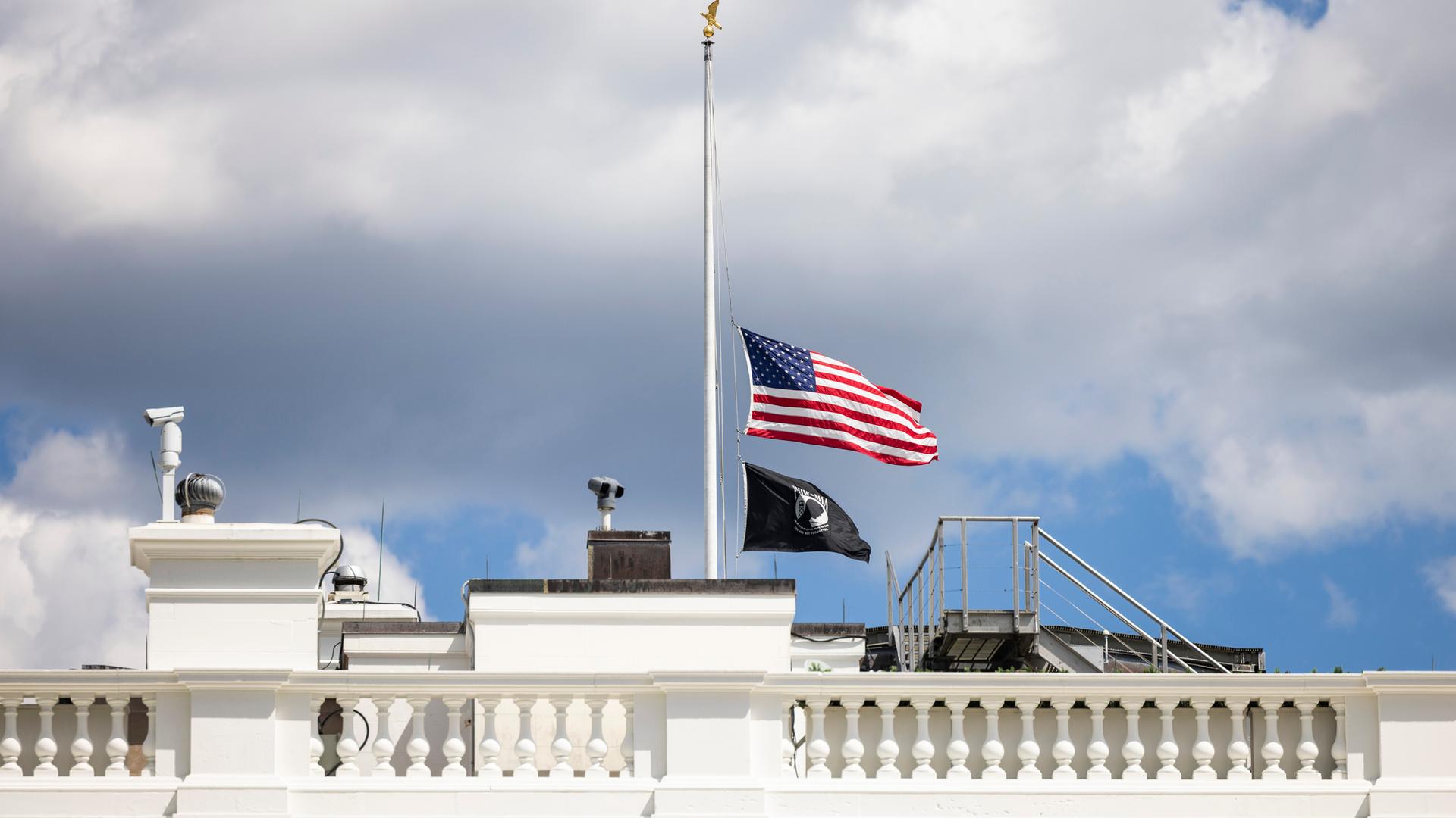 Weißes Haus mit Flagge auf Halbmast