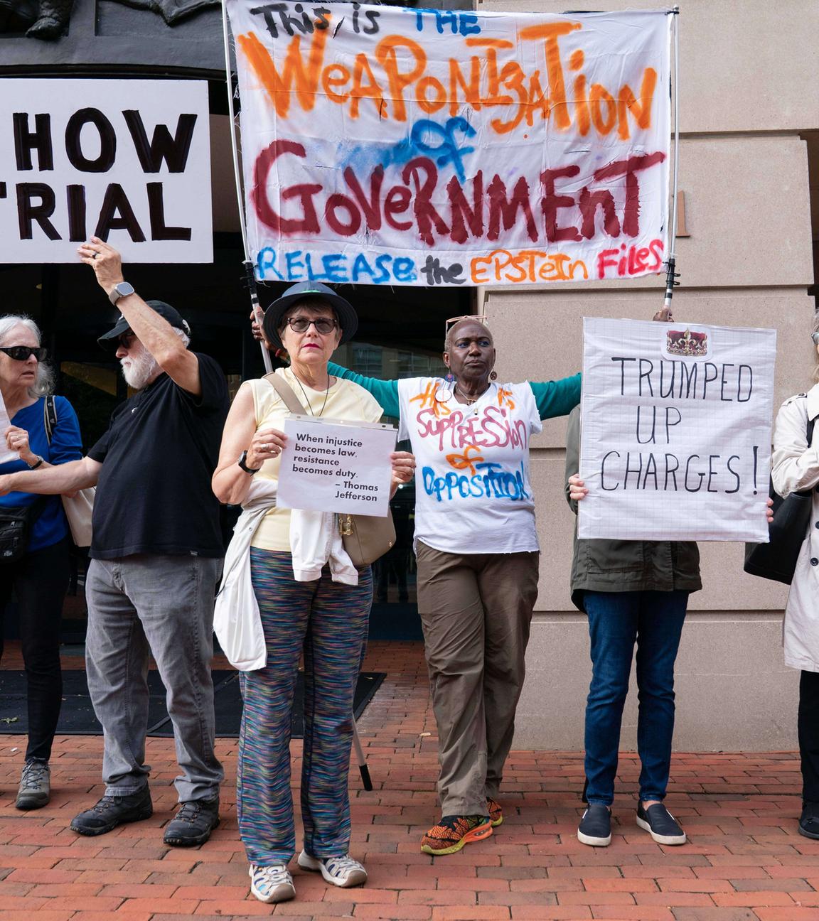 Vor dem US-Gerichtsgebäude in Virginia protestierten Demonstranten gegen die Anklage gegen Ex-FBI-Chef James Comey, der auf nicht schuldig plädierte.