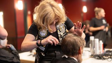 Friseurin schneidet Haare für guten Zweck