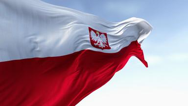 Nahaufnahme der polnischen Nationalflagge, die an einem klaren Tag im Wind weht - Bildmontage