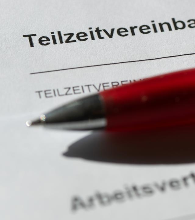 Ein Teilzeitsarbeitsvertrag auf dem ein roter Stift liegt