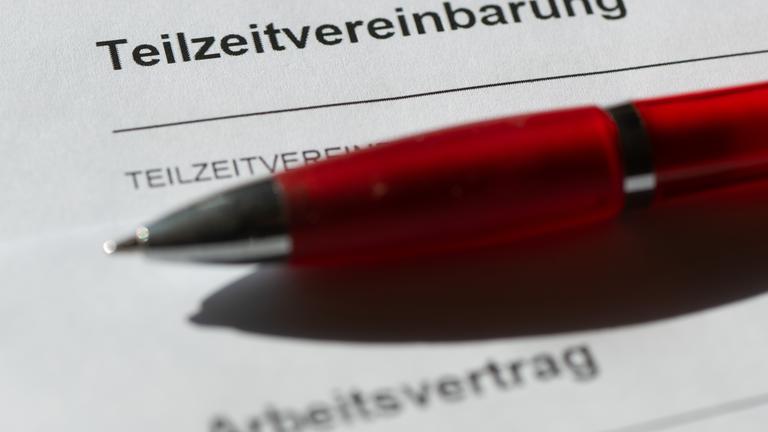 Ein Teilzeitsarbeitsvertrag auf dem ein roter Stift liegt