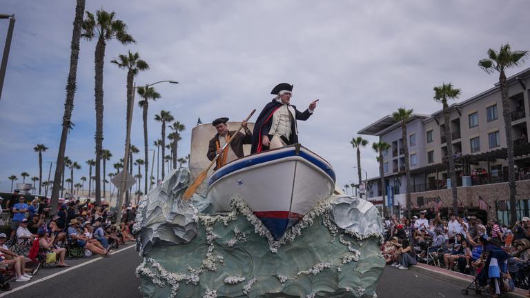Eine Person, die George Washington verkörpert, fährt während einer Parade zum Unabhängigkeitstag in Huntington Beach, Kalifornien, auf einem Festwagen mit.