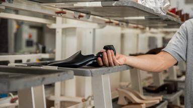 A shoe maker holding a shoe last inside the manufacturing factory   xkwx shoe fashion production mad
