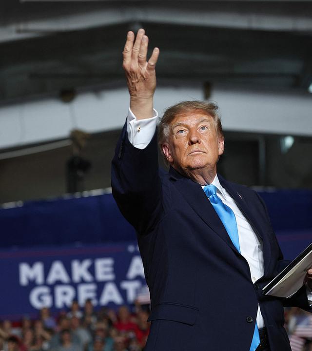 Donald Trump reckt auf einer Bühne einen Arm in die Höhe.