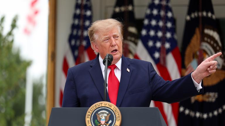Donald Trump spricht in ein Mikrofon im Rosengarten des Weißen Hauses.