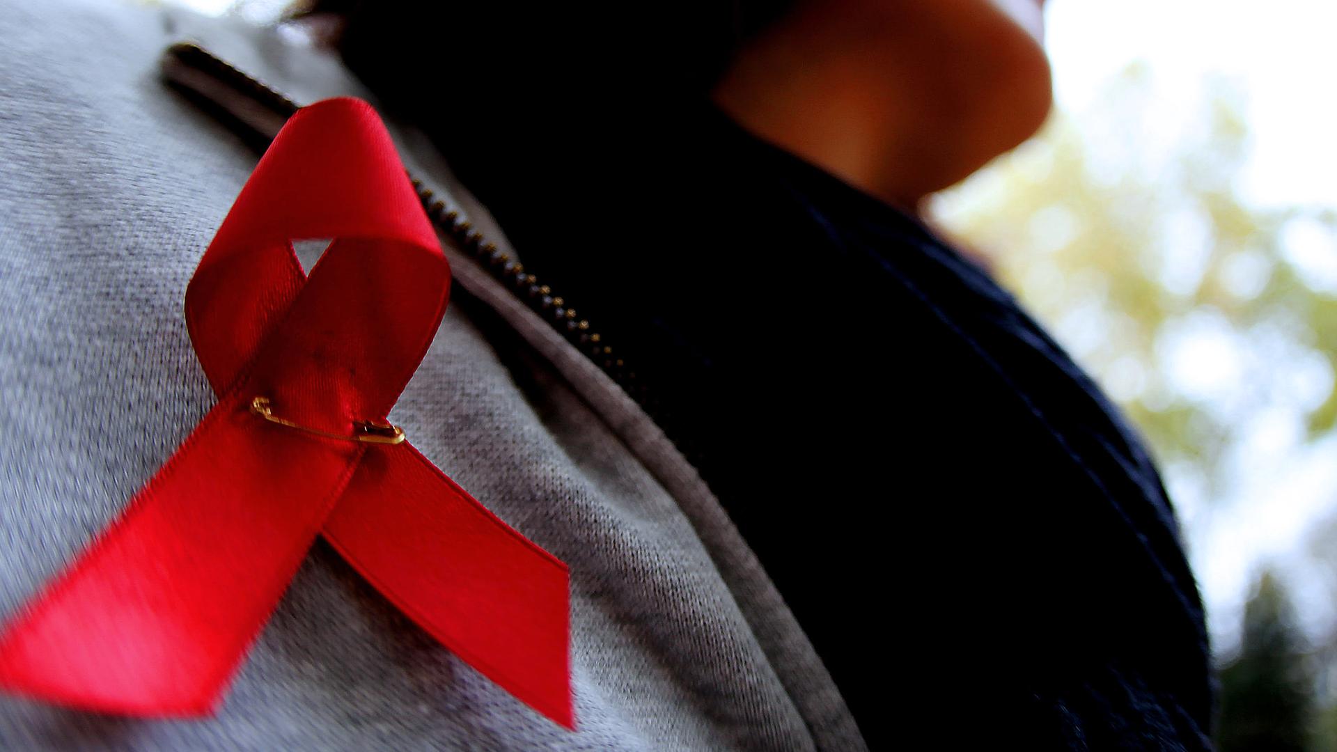 Archiv. Eine Frau trägt eine Aids-Schleife, aufgenommen am 06.11.2009