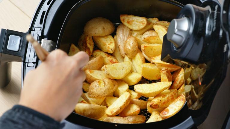 Heißluftfritteuse, in der Kartoffeln garen