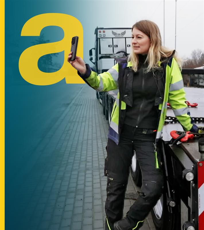 großes Auslandsjournal a im Vordergrund, daneben Frau steht mit Handy neben der Ladefläche von einem LKW