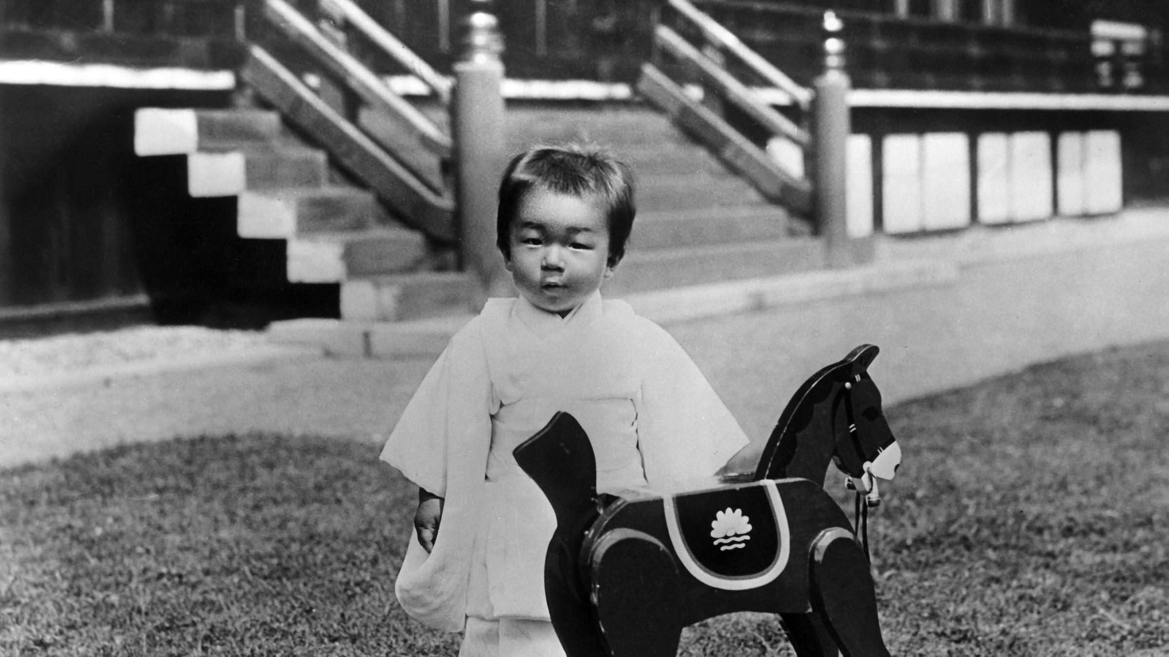Prinz Akihito von Japan mit seinem Schaukelpferd im Garten des kaiserlichen Palasts (Undatiertes Archivbild 1930er)