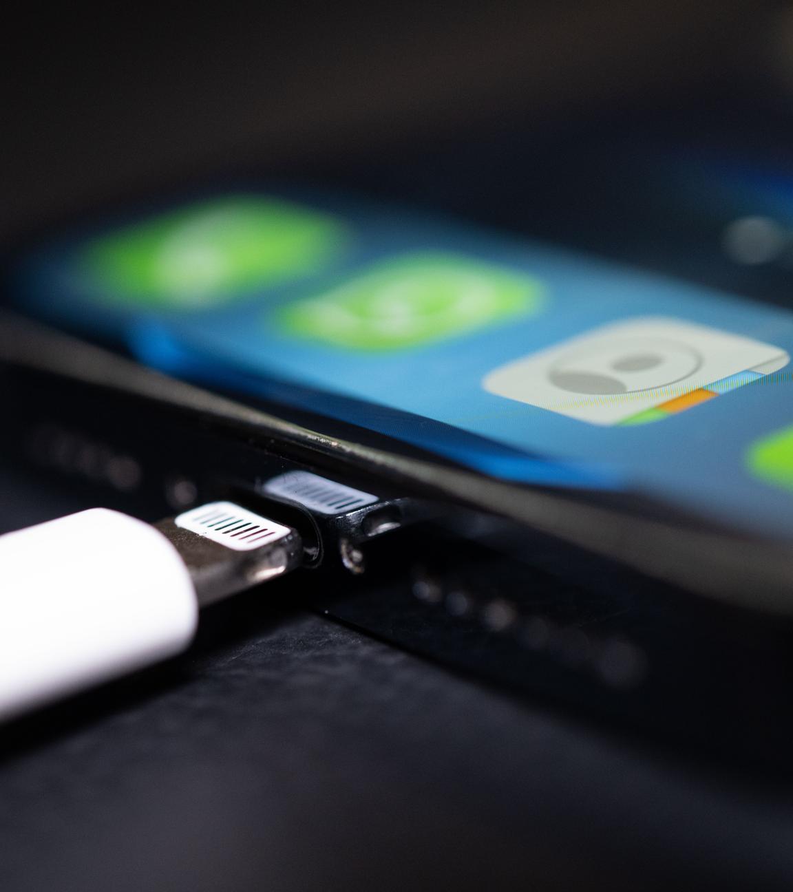 Ein Lightning-Ladestecker wird in ein Apple iPhone gesteckt.