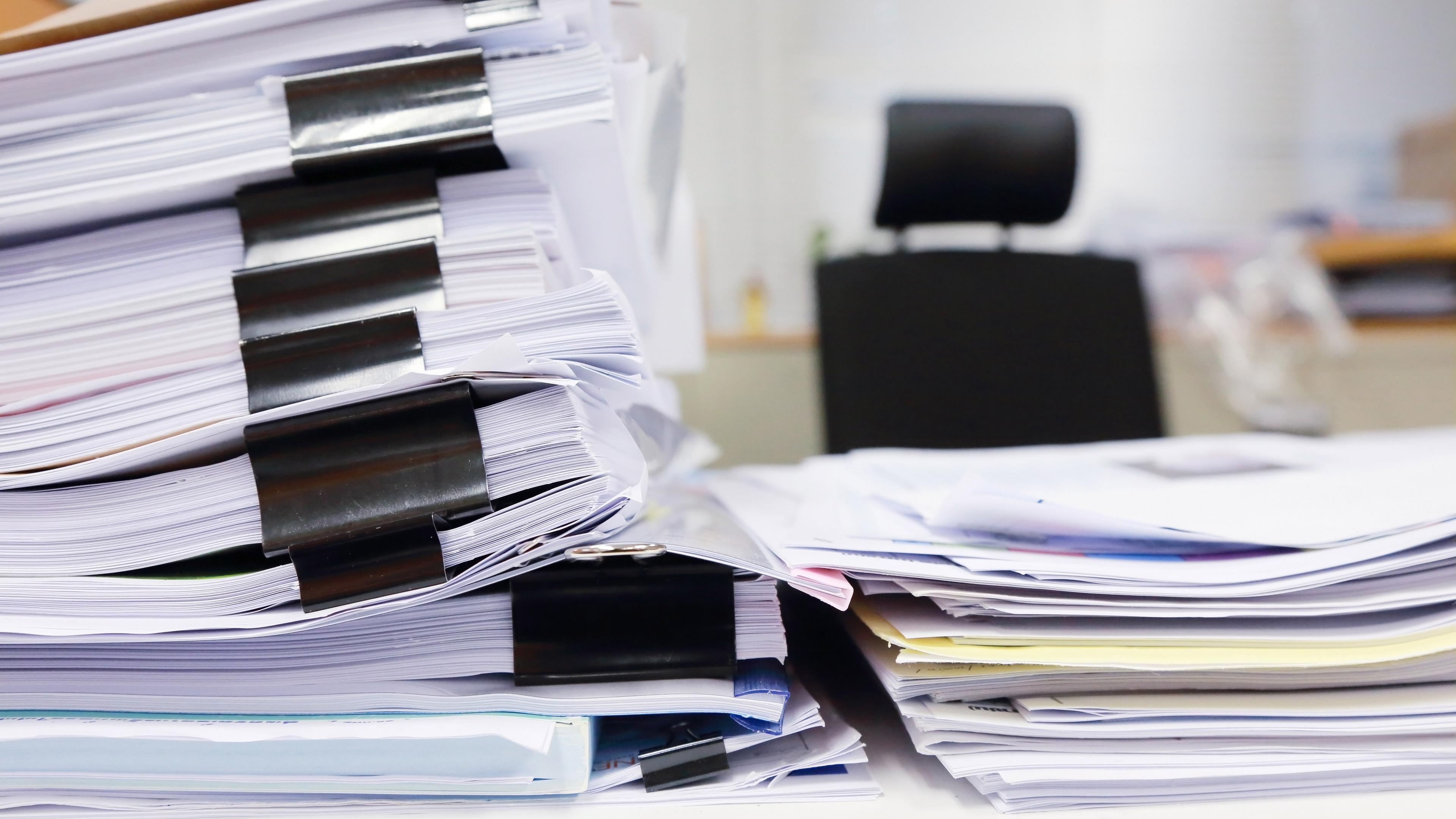 Aktenstapel auf einem Büroschreibtisch, Symbolbild