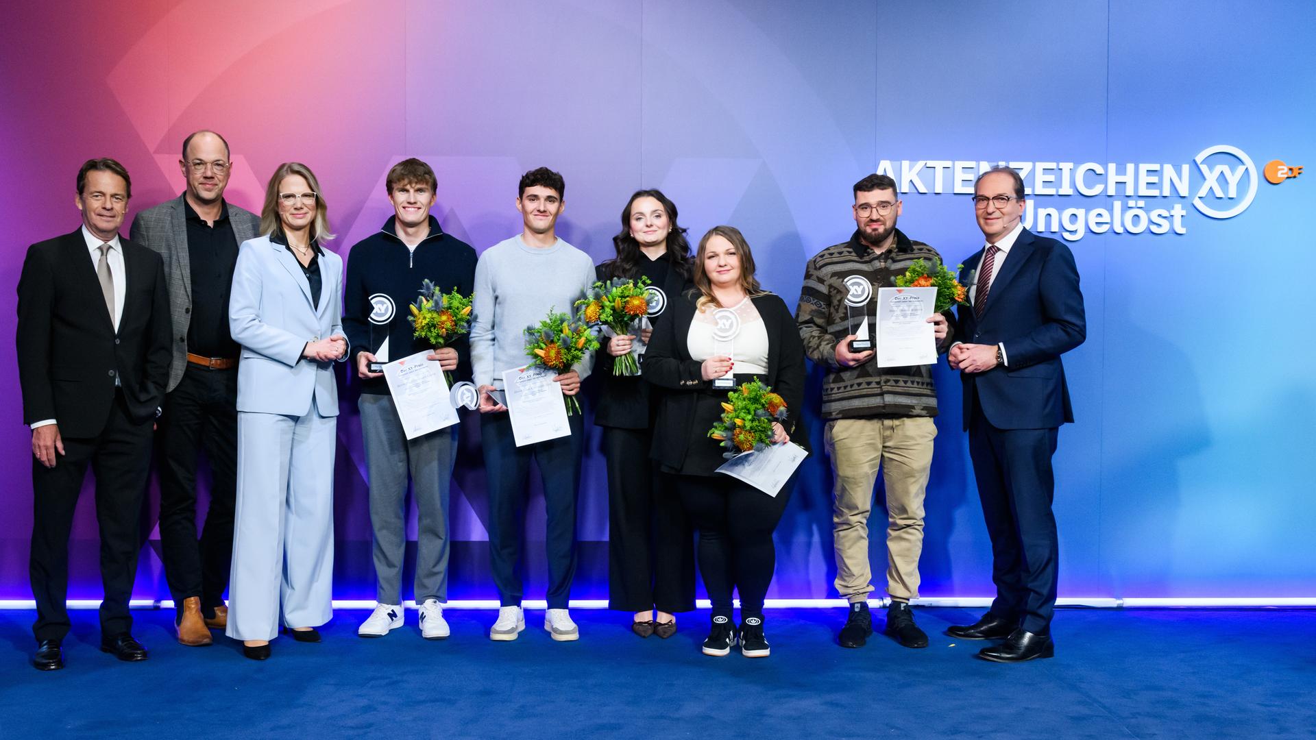 "Die Gewinner des XY-Preise 2025": von links Rudi Cerne,Frank Zervos, Nadine Bilke, Paul Georg, Elias Linz, Emma Tuscher, Inna Rommelfanger, Thomas Köpplin und Bundesinnenminister Alexander Dobrindt.