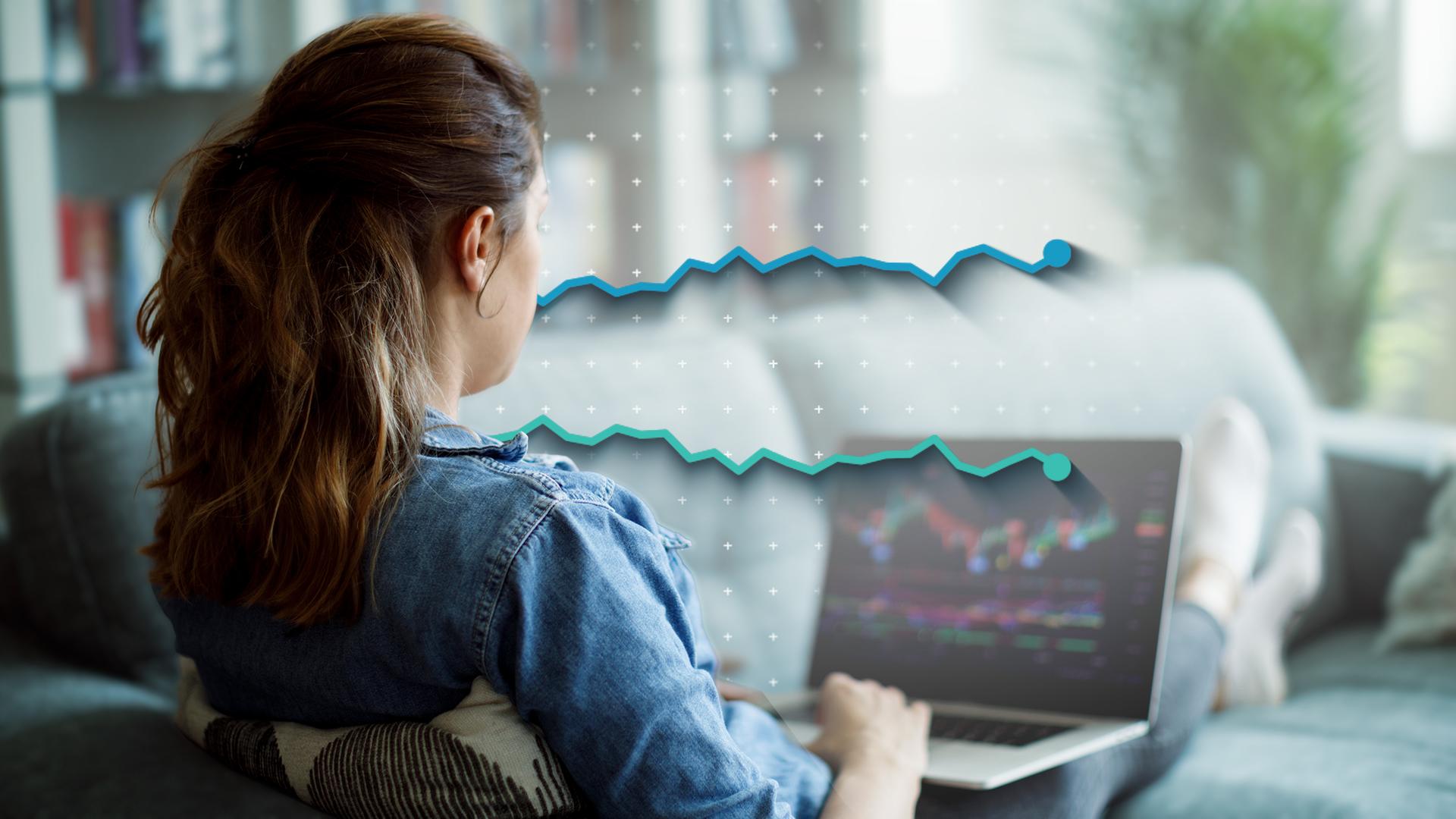 Ein Frau sitzt am Laptop und kauft Aktien.