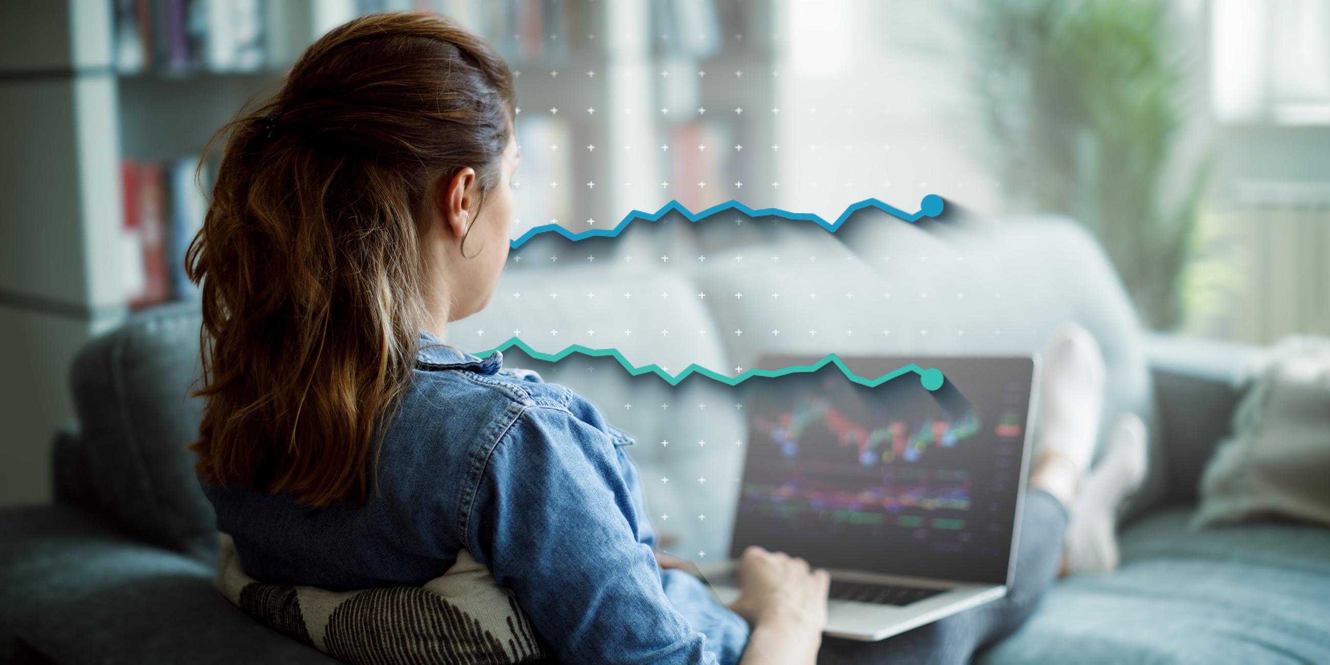 Ein Frau sitzt am Laptop und kauft Aktien.