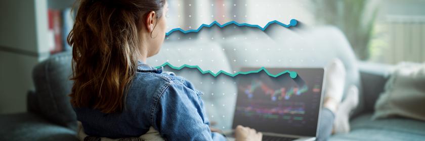 Ein Frau sitzt am Laptop und kauft Aktien.