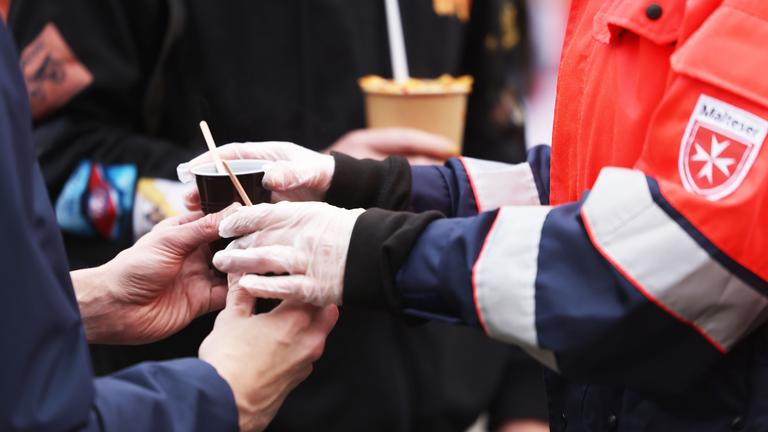 Mitarbeiter des Malteser Hilfsdienstes geben auf dem Friedensplatz vor dem Rathaus warme Getränke aus. Mit einem öffentlichen Essen zum Tag zur Überwindung der Armut haben Initiativen auf die Situation von Obdachlosen aufmerksam gemacht.