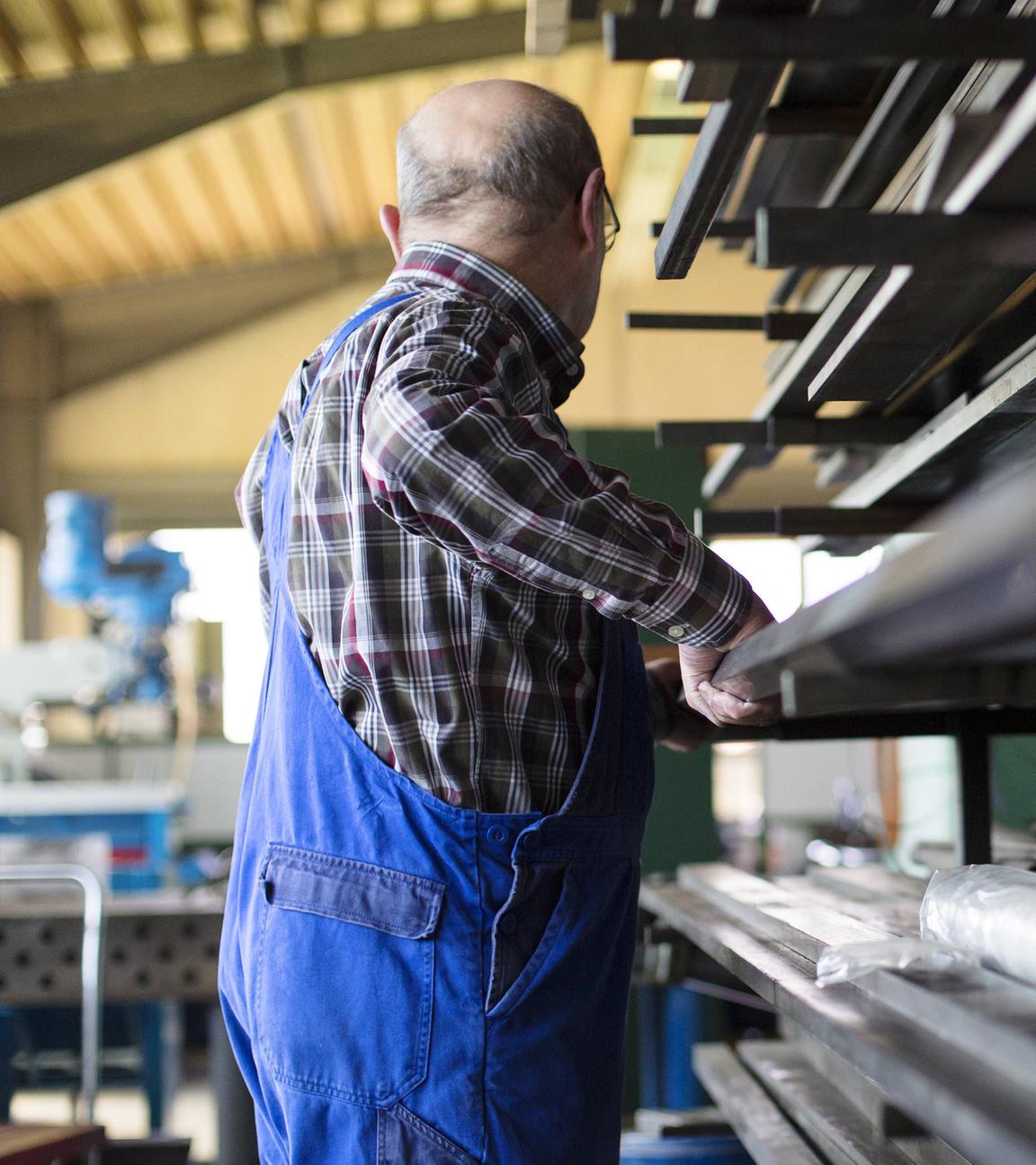 Ein älterer Herr arbeitet in einem mittelständischen Unternehmen für Maschinenbauteile in Sigmaringen südlich von Stuttgart