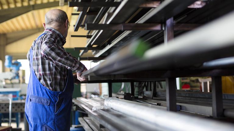 Ein älterer Herr arbeitet in einem mittelständischen Unternehmen für Maschinenbauteile in Sigmaringen südlich von Stuttgart