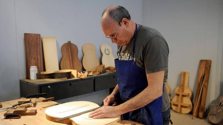 Ein Mann im Rentenalter arbeitet weiterhin als Instrumentbauer.