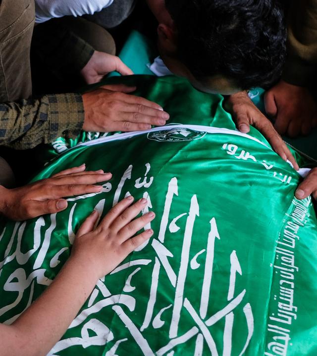 Palästinenser legen ihre Hände auf den mit einer Hamas-Flagge bedeckten Leichnam von Ezzedine Al-Haddad, dem Anführer der Qassam-Brigaden der Hamas, während seiner Beerdigung in Gaza-Stadt am Samstag, dem 16. Mai 2026.