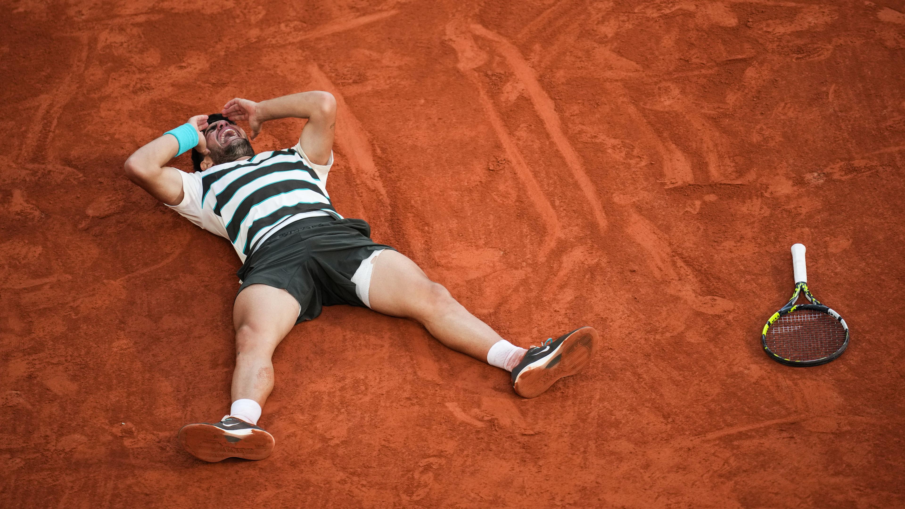 French Open, Finale, Sinner (Italien) - Alcaraz (Spanien): Sieger Carlos Alcaraz liegt nach dem Ende auf dem Rücken und jubelt.