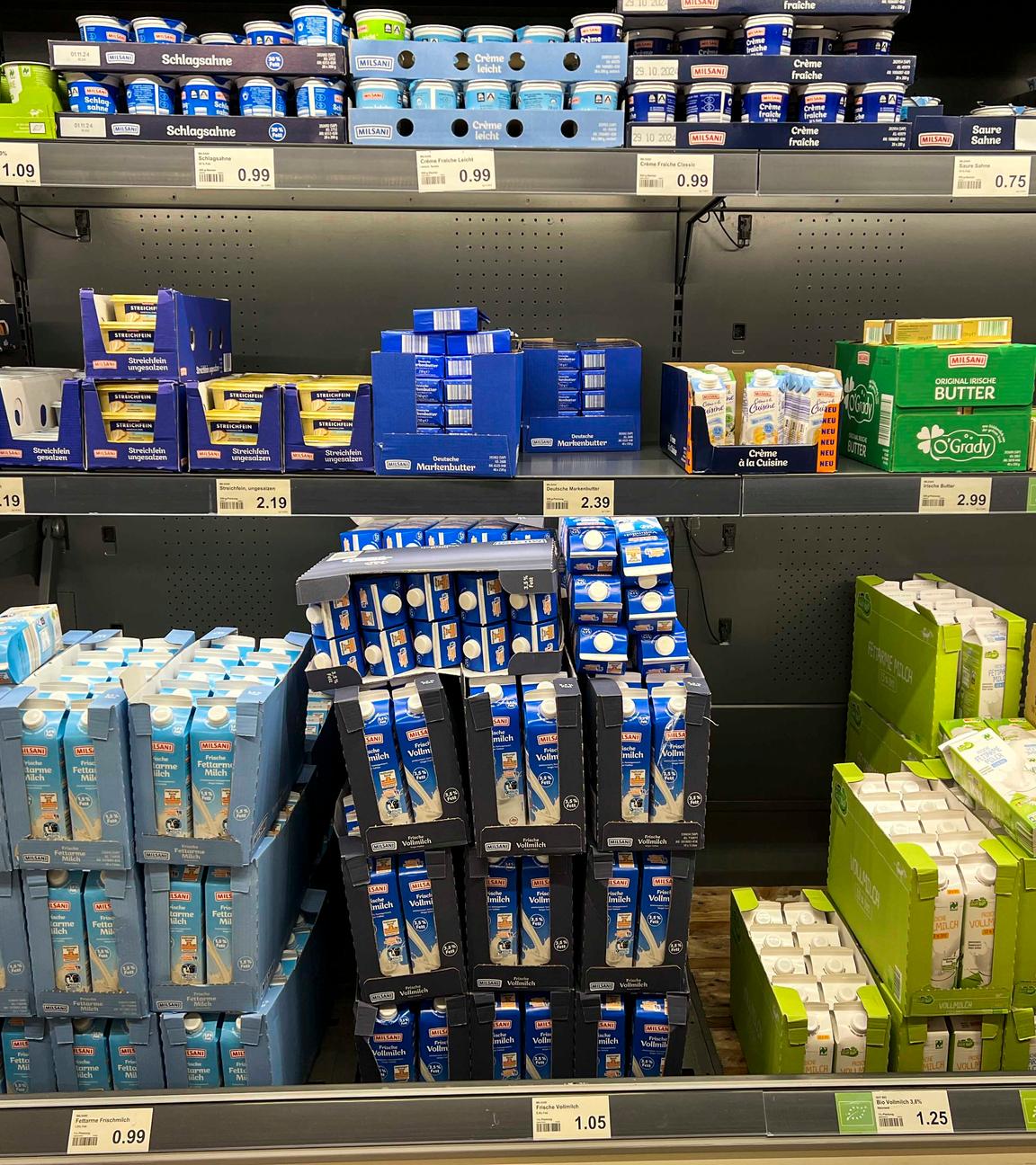 Blick auf ein Kühlregal in einem Supermarkt, gefüllt mit verschiedenen Milchprodukten.