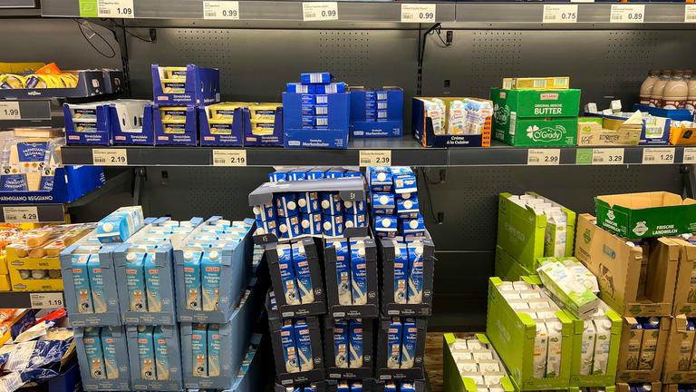 Blick auf ein Kühlregal in einem Supermarkt, gefüllt mit verschiedenen Milchprodukten.