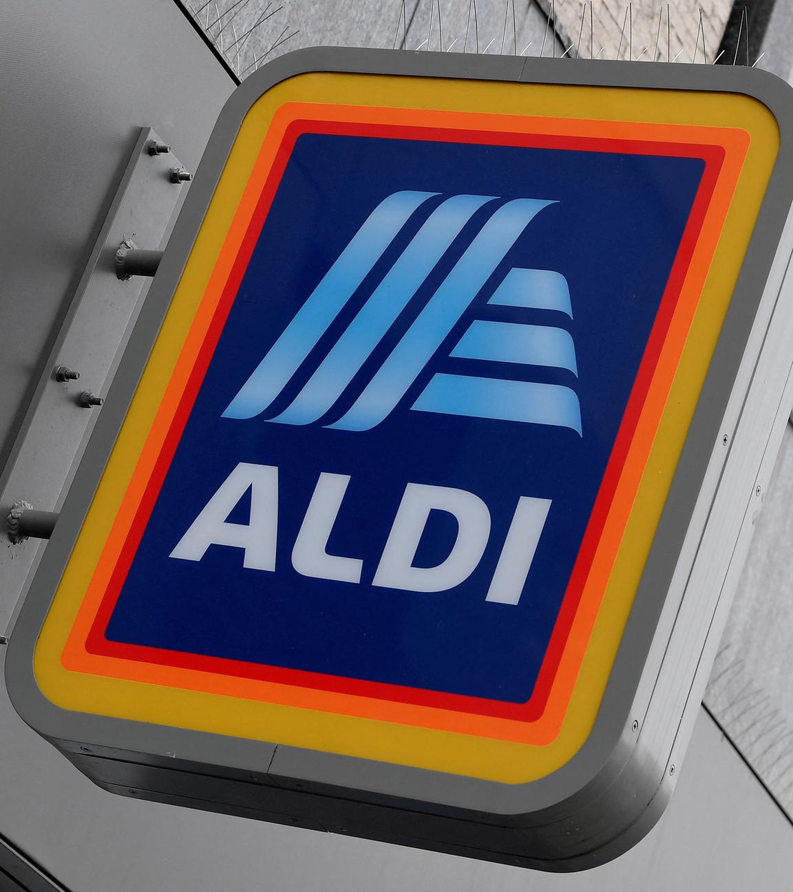 An einer Hausfassade ist ein Schild des Aldi-Logos angebracht.
