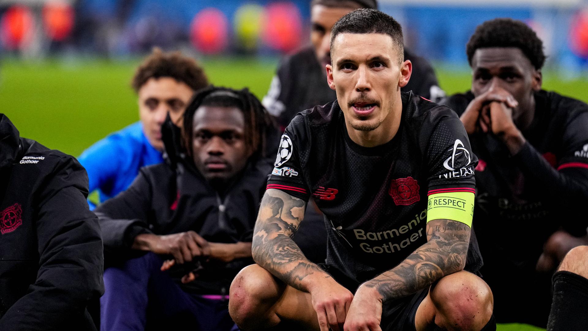 Fußballer Alejandro Grimaldo von Bayer 04 Leverkusen blickt nach dem Spiel der UEFA Champions League 2025/26, zwischen Manchester City und Bayer 04 Leverkusen im City of Manchester Stadium am 25.11.2025 in Manchester, England, zu.