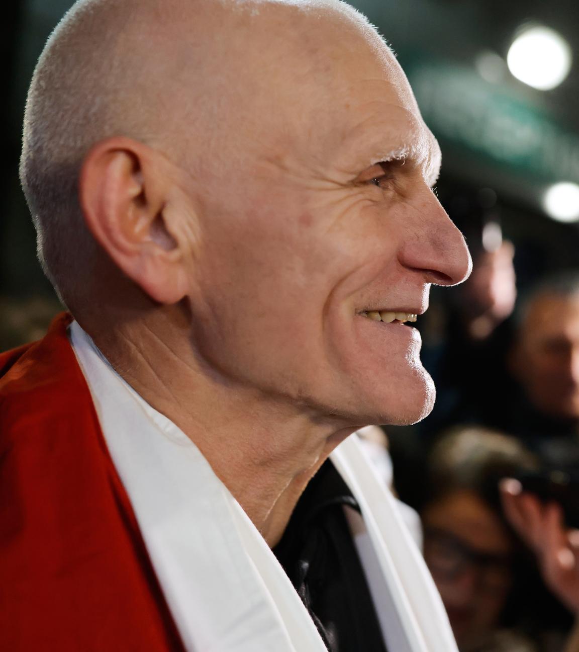 Der Friedensnobelpreisträger Ales Bjaljazki, einer der freigelassenen belarussischen Gefangenen, lächelt, als er am 13.12.2025, in der US-Botschaft in Vilnius, Litauen, eintrifft, während die belarussische Oppositionsführerin Sviatlana Tsikhanouskaya (im Hintergrund) daneben steht.