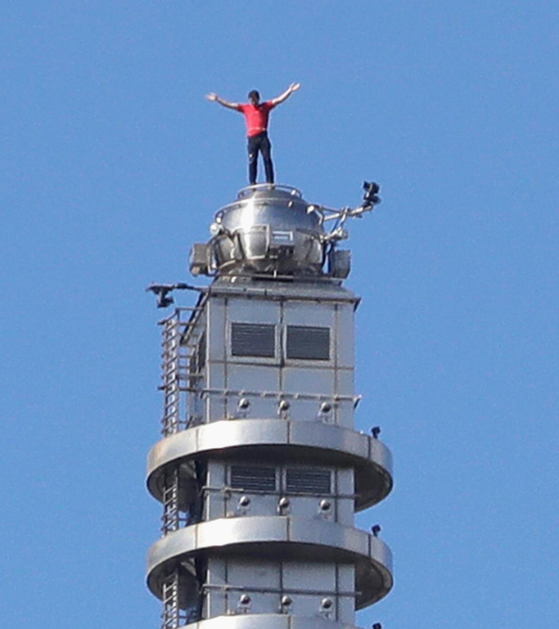 Der US-amerikanische Bergsteiger Alex Honnold hebt die Hände, nachdem er ohne Sicherung auf den Wolkenkratzer Taipei 101 in Taipeh, Taiwan, klettert.
