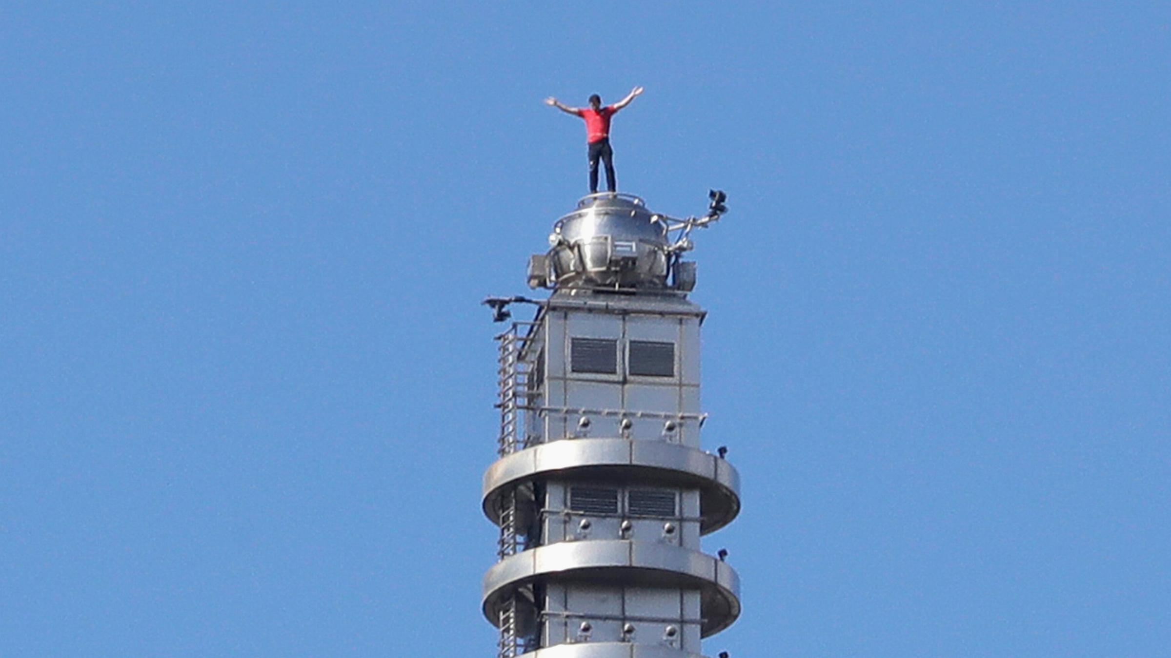 Der US-amerikanische Bergsteiger Alex Honnold hebt die Hände, nachdem er ohne Sicherung auf den Wolkenkratzer Taipei 101 in Taipeh, Taiwan, klettert.