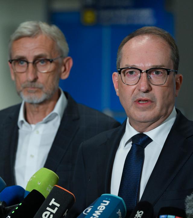 Alexander Dobrindt (CSU, r), Bundesinnenminister, spricht bei einer Pressekonferenz in einem Terminal des Flughafens Leipzig/Halle.